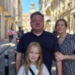 A man, a woman and a 10-year-old girl stand in the main public square in Arles.