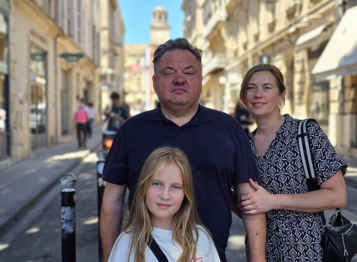 A man, a woman and a 10-year-old girl stand in the main public square in Arles.