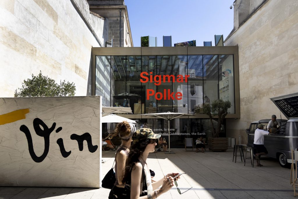 A woman walks in front of a museum