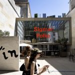 A woman walks in front of a museum