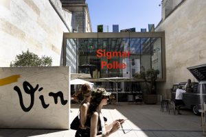 A woman walks in front of a museum