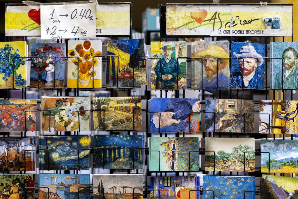 Postcards featuring the colorful paintings of Vincent van Gogh sit on a rack.