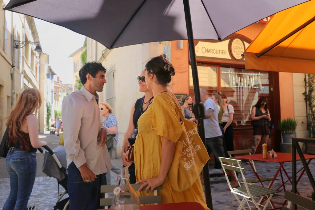 People stand chatting on a street in Arles