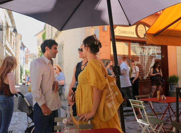 People stand chatting on a street in Arles