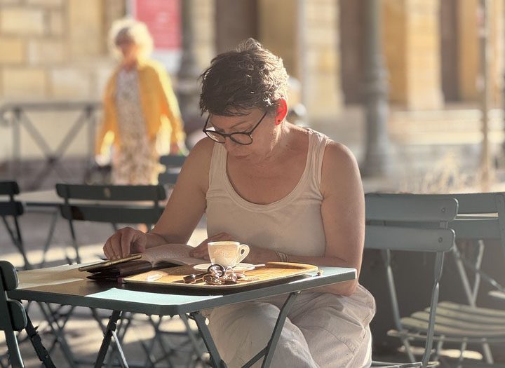 A woman sits at a cafe reading.