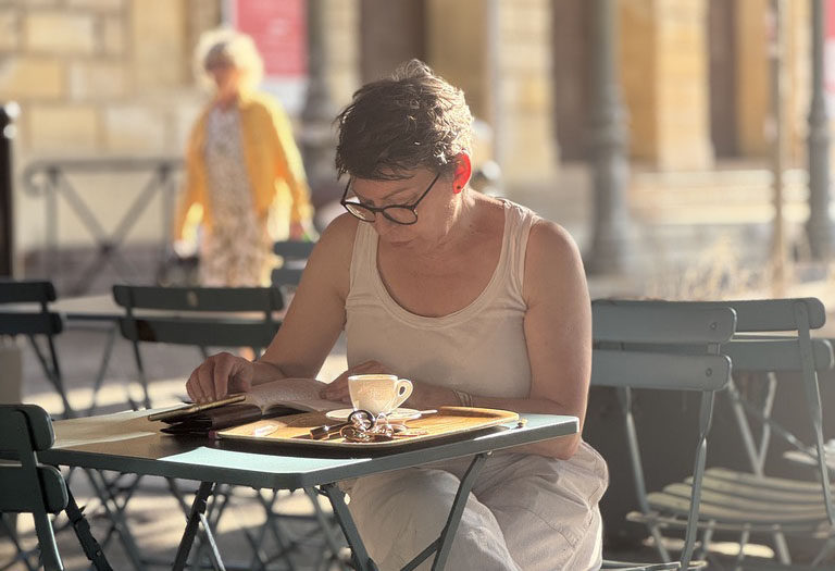 A woman sits at a cafe reading.