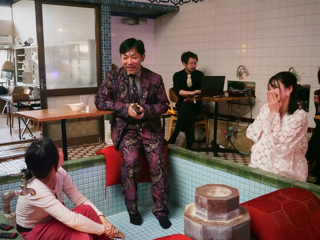 People gather in a tub at an old Japanese bathhouse.