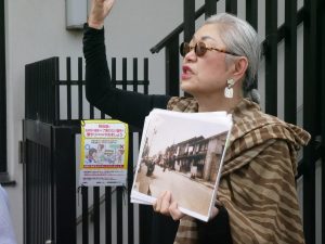 A woman hold up a picture showing what the Sujin neighborhood used to look like.