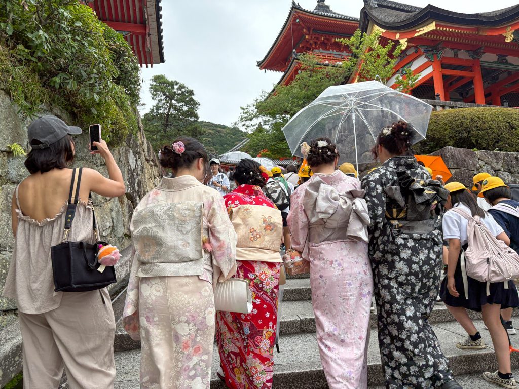 A group of women in kimonos walk on a street in Kyoto