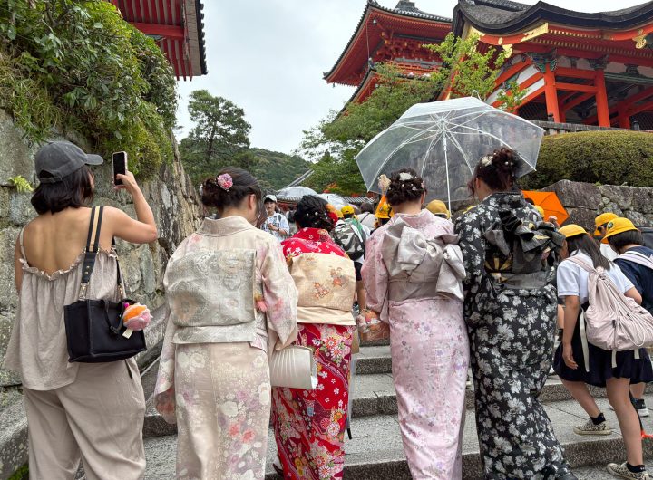 A group of women in kimonos walk on a street in Kyoto