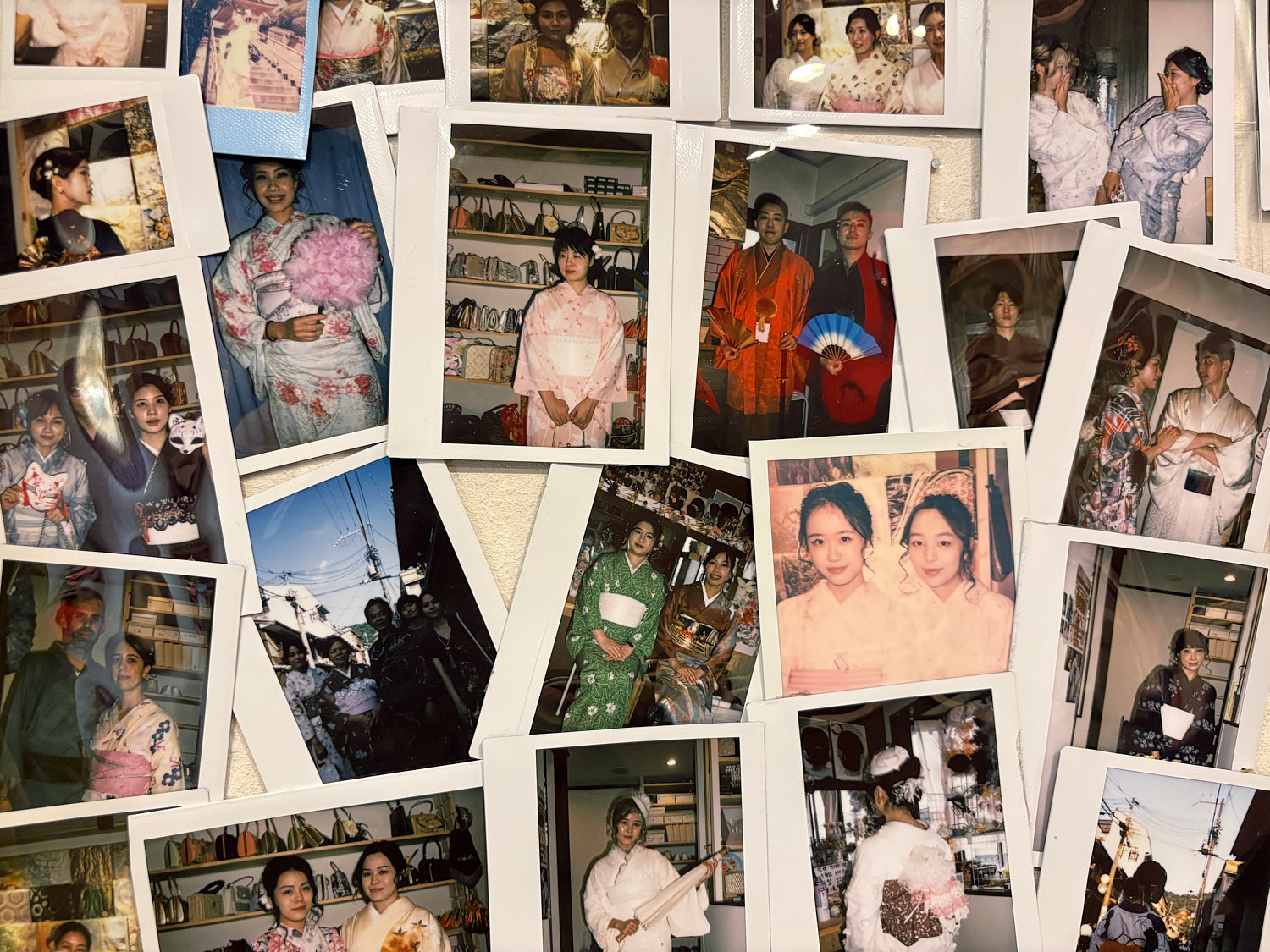 A wall of Polaroid photos shows people dressed in kimonos.