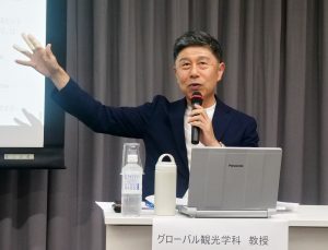 Toshihiko Goto, gestures at the panel discussion.