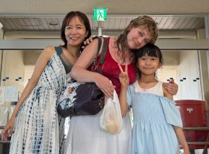Emma Cooney, center, stands with her new friends, Aoi, left, and her daughter, Sumi, right at the ferry port on Taketomi.