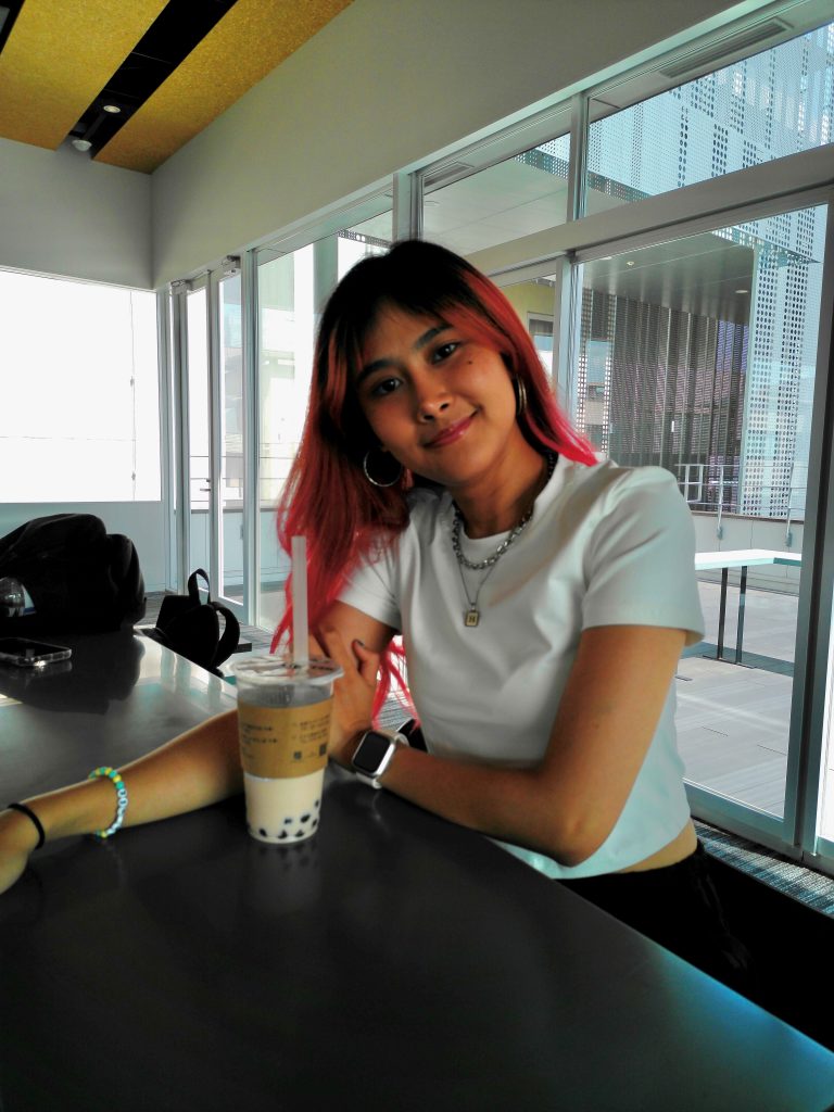 Happy Ayuni has a drink at a counter.